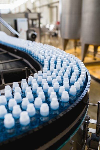 Bottling plant - Water bottling line for processing and bottling pure spring water into blue bottles. Selective focus.